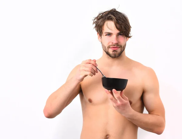 Caucásico sexy joven macho sosteniendo tazón negro con tenedor — Foto de Stock