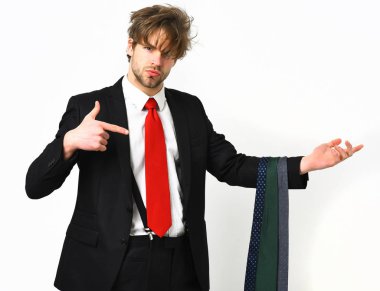 Sakallı, maço, şık takım elbiseli, kravatlı bir adam.