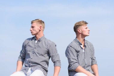 yakışıklı İkizler gökyüzü arka plan üzerinde ciddi yüzü olan poz