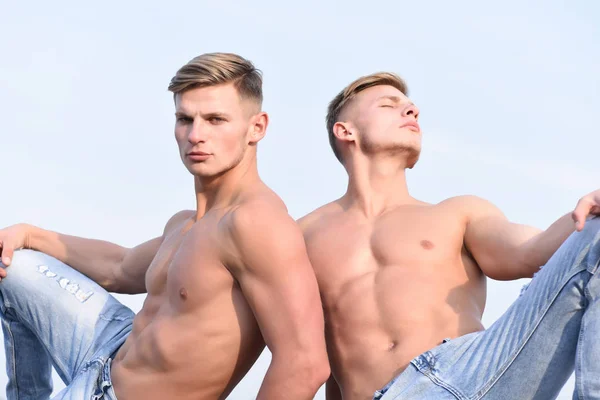 Jeunes jumeaux beaux posant sur fond de ciel avec un visage sérieux — Photo