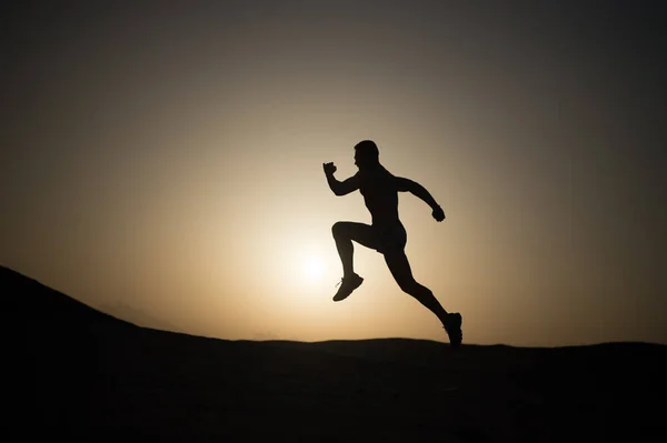 Man running silhouette at sunset, young caucasian run in mountain — Stock Photo, Image