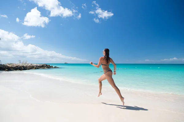 Młoda kobieta biegająca na tropikalnej plaży — Zdjęcie stockowe