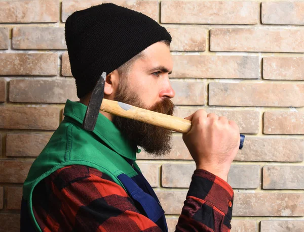 Бородатый строитель держит молоток серьезное лицо — стоковое фото
