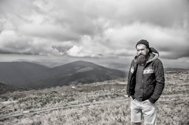 doğal bulutlu gökyüzü rüzgarlı dağın tepesinde sakallı adam