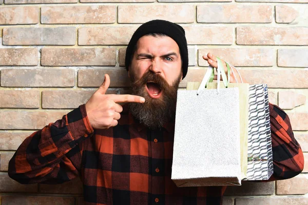 Bärtiger brutaler kaukasischer Hipster mit Schnurrbart hält Einkaufspakete in der Hand — Stockfoto