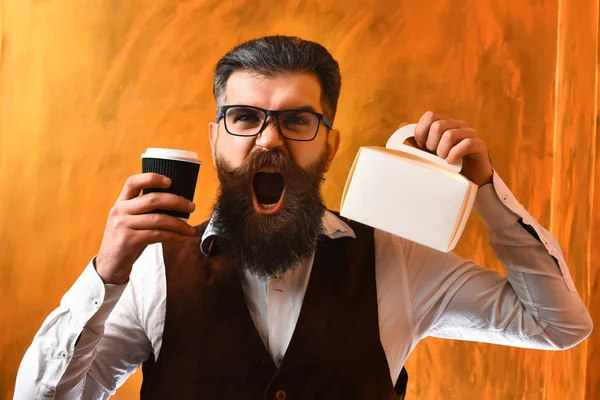 Bearded man, brutal caucasian hipster holding coffee and meal box