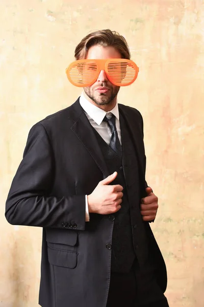 Смешной бизнесмен позирует в смешных оранжевых больших очках для вечеринок — стоковое фото