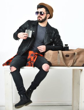 Sakallı, beyaz, bıyıklı, elinde matarası olan bir hippi.