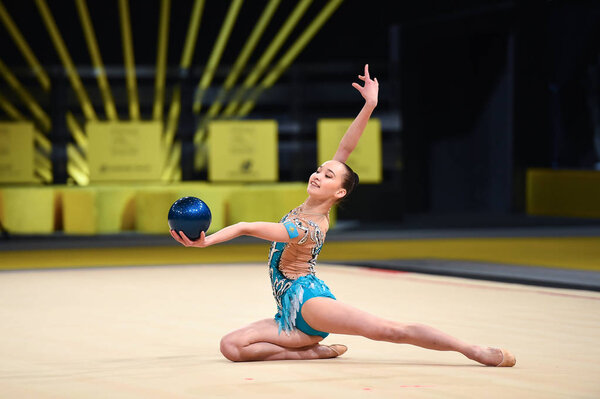 гимнастка выступает на соревнованиях по художественной гимнастике

