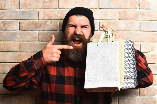 Bärtiger brutaler kaukasischer Hipster mit Schnurrbart hält Einkaufspakete in der Hand — Stockfoto