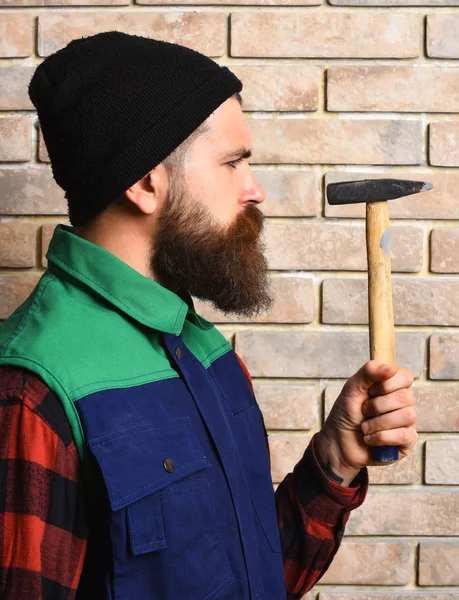 Barbudo construtor homem segurando martelo rosto sério — Fotografia de Stock