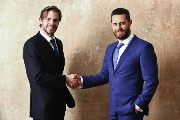 Hombres felices en chaqueta se toman de la mano en apretón de manos — Foto de Stock