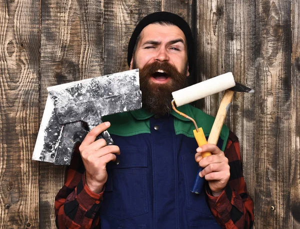 Bärtiger Bauarbeiter mit verschiedenen Bauwerkzeugen und glücklichem Gesicht — Stockfoto