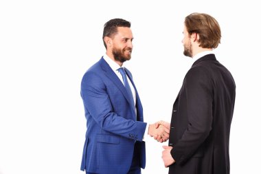 Ceketli mutlu adamlar el sıkışırken el ele tutuşuyorlar.