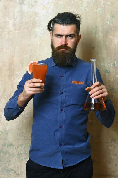 Brutal hipster sosteniendo una inyección alcohólica y un tubo o frasco de vidrio — Foto de Stock