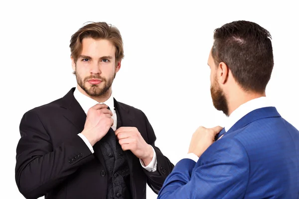 Бизнесмены в синем и черном костюме завязывают галстук — стоковое фото