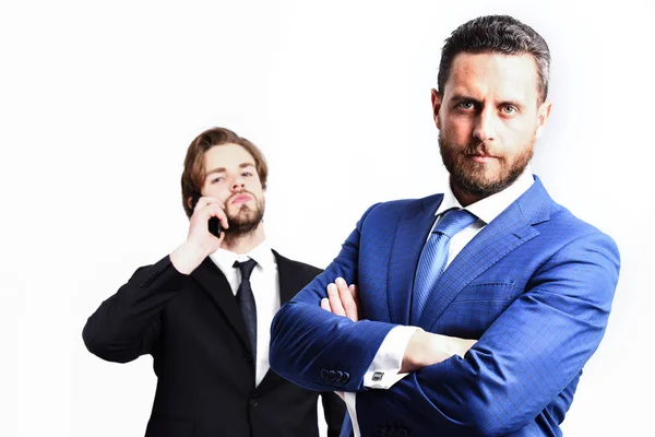 Серьезный бизнесмен в синем костюме и мужчина разговаривает по телефону — стоковое фото