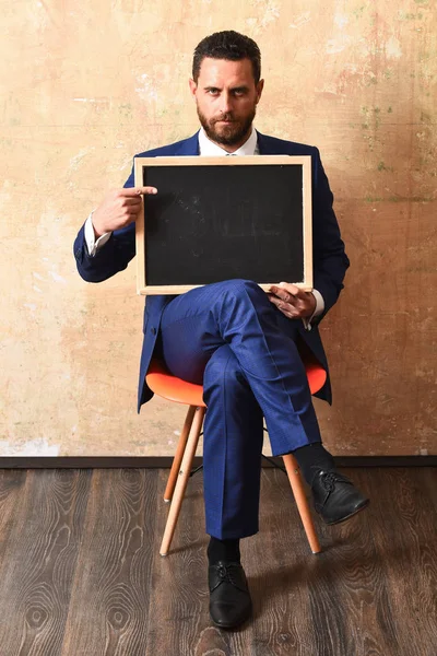 Businessman or serious man holding a blackboard — Stock Photo, Image