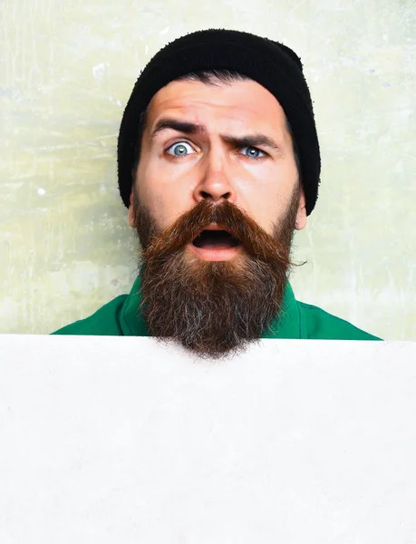 Бородатий чоловік позує на фоні стіни студії — стокове фото