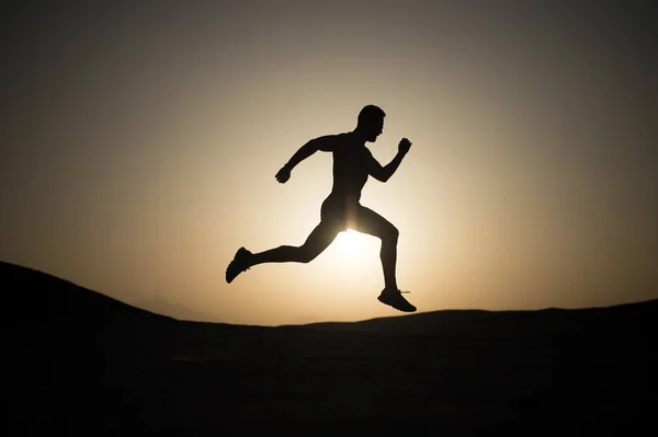 Силуэт бегущего человека на закатном небе — стоковое фото