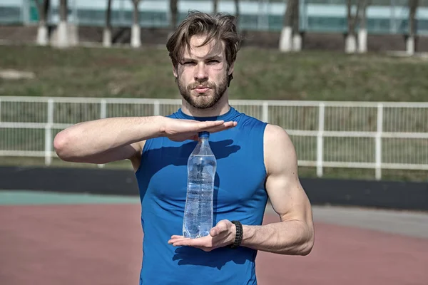 Guapo musculoso hombre sostiene botella de agua — Foto de Stock