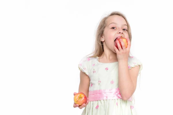 Χαριτωμένο κοριτσάκι τρώει ένα μήλο απομονωμένο σε λευκό φόντο — Φωτογραφία Αρχείου