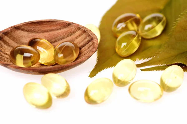 Fish oil omega 3 gel capsules in spoon with leaf — Stock Photo, Image