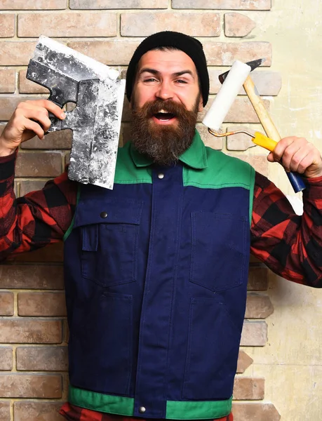 Vousatý stavitel muž drží různé stavební nástroje se šťastnou tváří — Stock fotografie