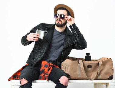 Sakallı, beyaz, bıyıklı, elinde matarası olan bir hippi.