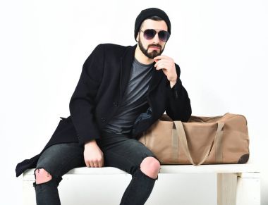 Sakallı bir adam, şık çantasının yanında bıyıklı beyaz bir hippi.