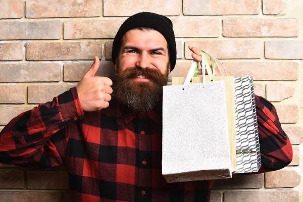 Bärtiger brutaler kaukasischer Hipster mit Schnurrbart hält Einkaufspakete in der Hand — Stockfoto