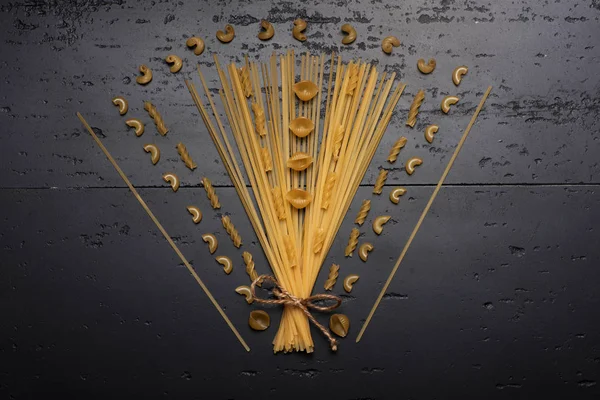 Bukett av torr pasta på en mörk grå yta — Stockfoto