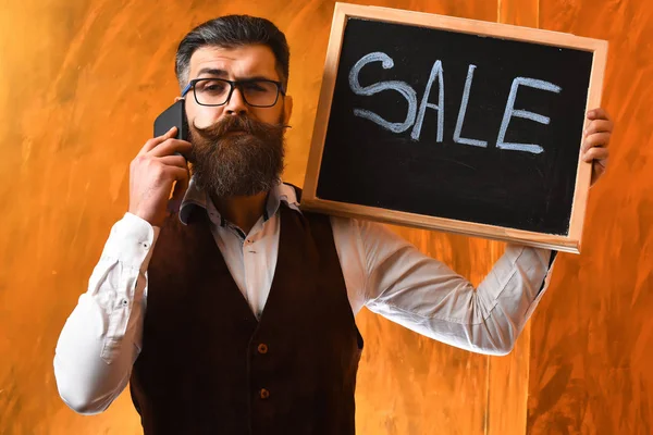 Hombre barbudo, brutal hipster caucásico con inscripción de venta de teléfonos inteligentes —  Fotos de Stock