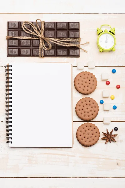 Composizione di dolci, sveglia verde e quaderno — Foto Stock