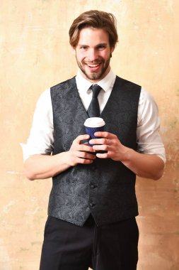 Takım elbiseli bir iş adamının elinde kahve kağıdı.