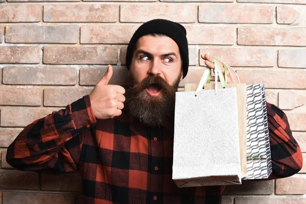 Bärtiger brutaler kaukasischer Hipster mit Schnurrbart hält Einkaufspakete in der Hand — Stockfoto