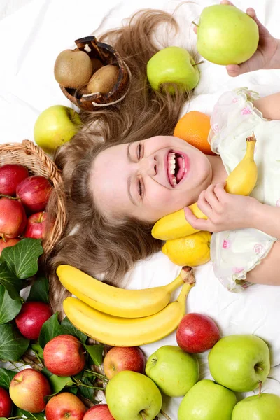 Niño, linda niña acostada con frutas de colores —  Fotos de Stock