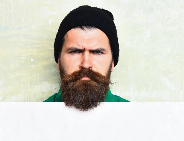 Бородатий чоловік позує на фоні стіни студії — стокове фото