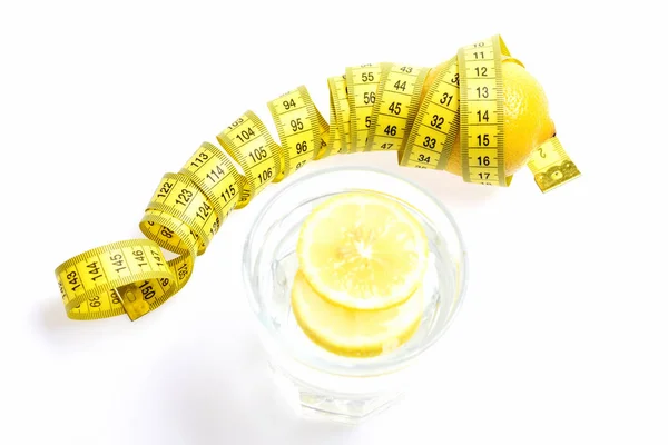 Concepto de nutrición y dieta. Cinta métrica atada alrededor de limón aislado — Foto de Stock