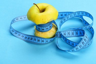 Mavi ölçü bandı tarafından sarılmış ısırıldı elma
