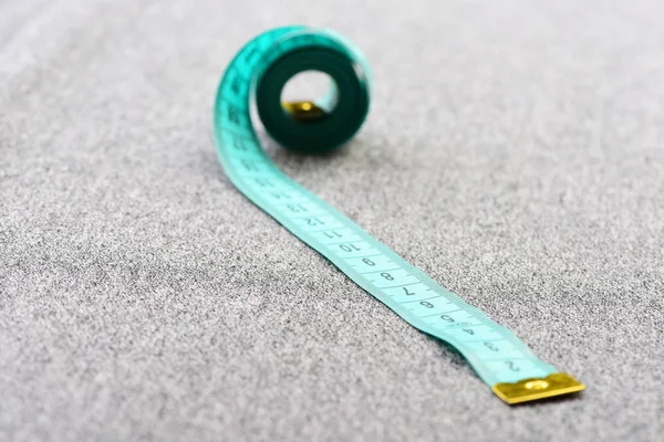 Spinned measure tape in light blue colour