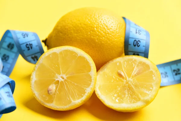 Cinta métrica y limón sobre fondo amarillo, fruta sana — Foto de Stock