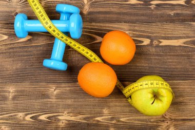 egzersiz kavramı, dumbell ağırlık ölçüm bandı, portakal ve elma ile