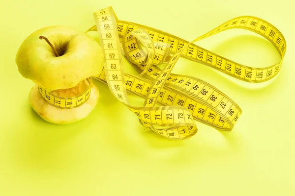Concepto de dieta representado por manzana atada con cinta métrica — Foto de Stock