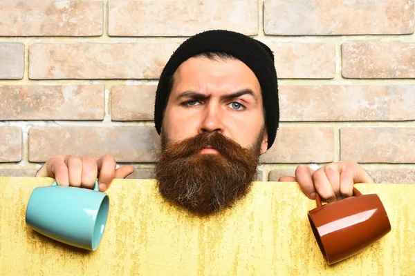 Barbudo brutal hipster caucásico con hoja de papel y tazas —  Fotos de Stock