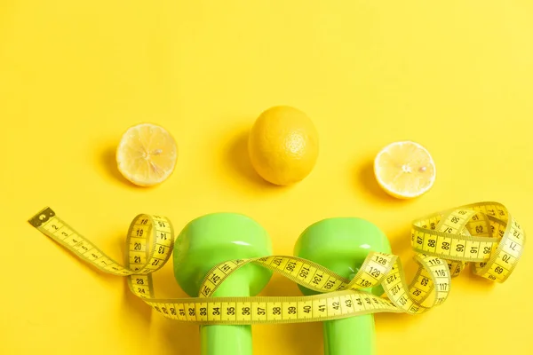 Nutrición, concepto de dieta. Cinta métrica torcida alrededor de pesas aisladas de color blanco — Foto de Stock