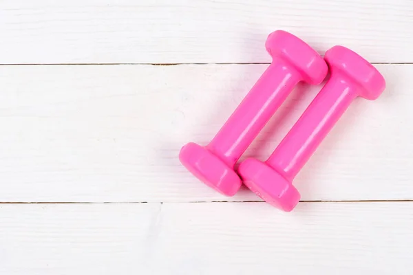Manubri rosa su legno bianco vintage, concetto di allenamento — Foto Stock