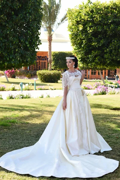 Jolie femme en robe de mariée blanche, maquillage à la mode et cheveux — Photo