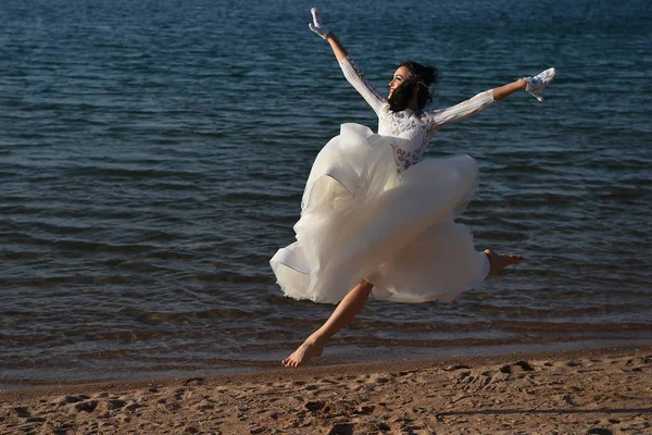 Vestido de novia en correr mujer feliz en verano playa agua — Foto de Stock