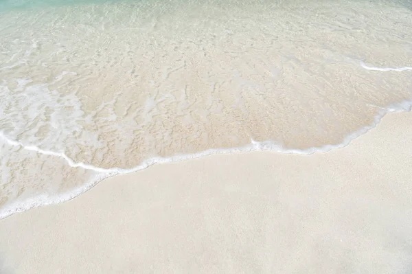 Vågiga havet, ocean vatten bakgrund på sand coast i Antigua — Stockfoto